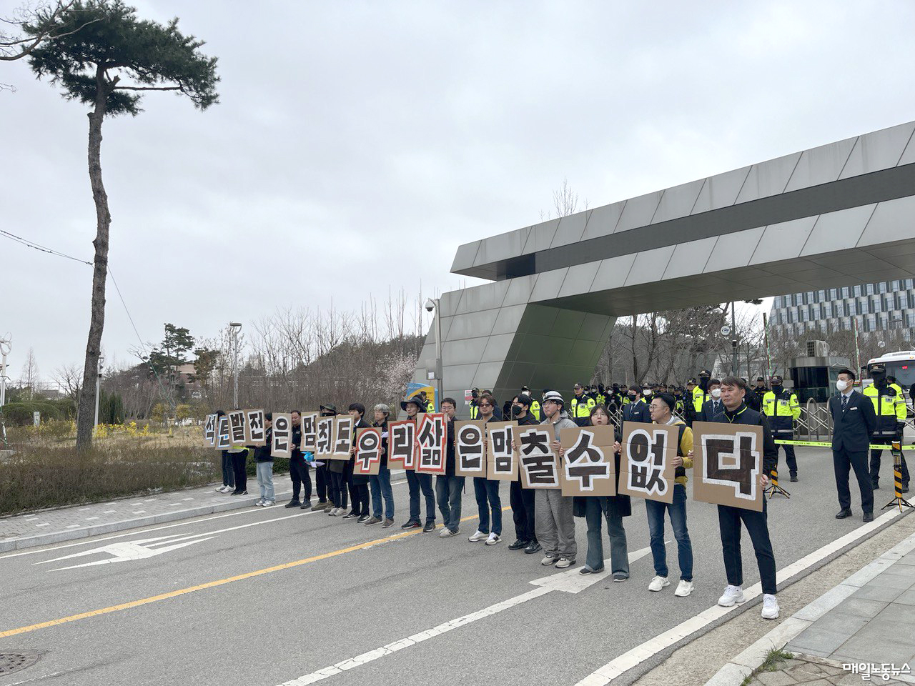 지난 30일 오후 태안군에서 열린 정의로운 전환을 위한 충남노동자행진을 완주한 참가자들이 한국서부발전 본사 앞에서 손팻말을 들고있다. <정소희 기자>