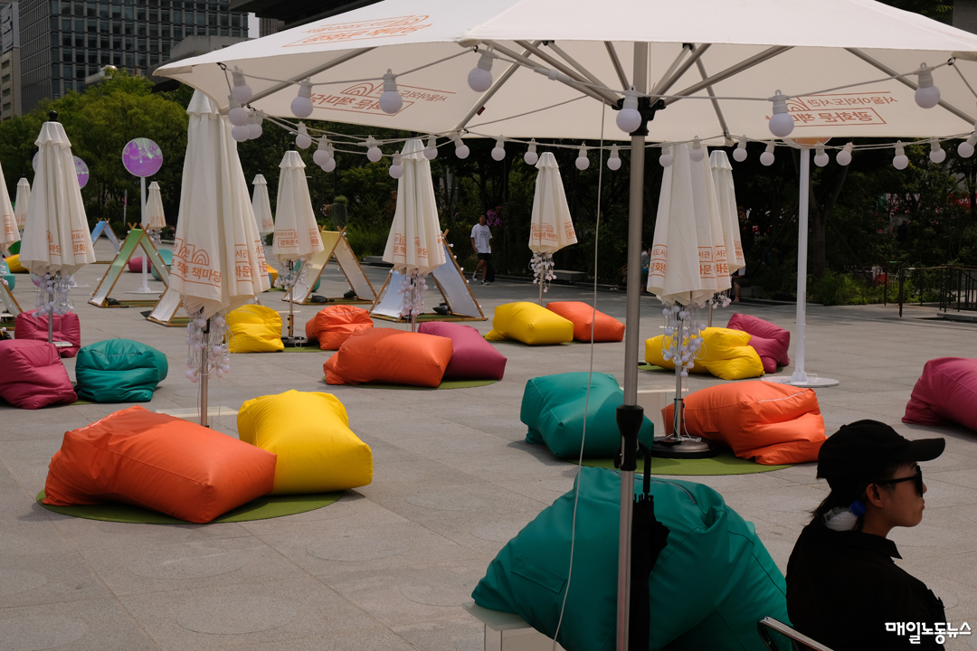 독서 열기는 한낮의 열기를 넘지 못했다. 광화문 광장 책마당에 알록달록 화려한 쿠션이 텅 비었다. 행사 관계자가 홀로 앉아 더위를 견디고 있다. 목 뒤쪽엔 얼음물을 끼웠다. <정기훈 기자>