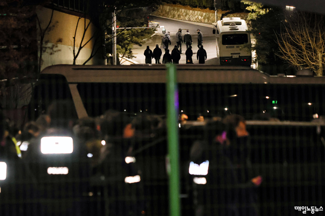 15일 새벽 서울 용산구 한남동에서 윤석열 대통령 체포영장 집행 개시 전 대통령 경호처 관계자로 추정되는 인물들이 대통령 관저 문 근처로 나왔다 들어가고 있다. <윤성희 기자>