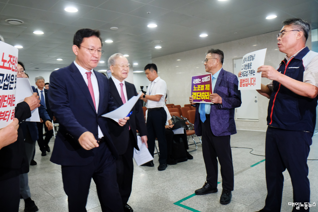 손경식 경총 회장과 김형동 국민의힘 의원이 18일 노조법 개정 반대 기자회견을 하기 위해 국회 소통관으로 들어가고 있다. 노조법2·3조 개정운동본부 회원들이 노조법 개정울 촉구하는 팻말을 들고 서 있다. <정기훈 기자>