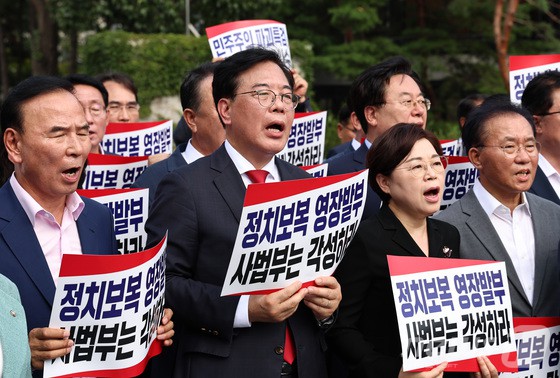 송언석 비상대책위원장 겸 원내대표를 비롯한 국민의힘 의원들이 18일 오후 서울 서초구 서울중앙지방법원 앞에서 열린 현장비상의원총회에서 구호를 외치고 있다.